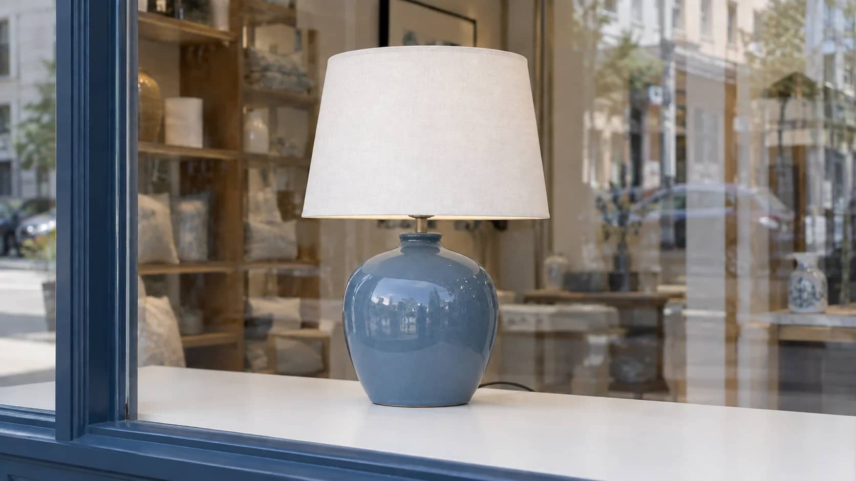 A ceramic table lamp clearly visible in a homewares-shop window.
